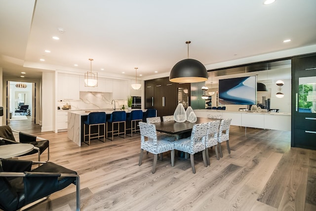 dining space with sink and light hardwood / wood-style floors