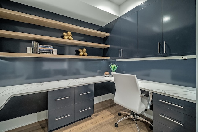 office space with built in desk and light wood-type flooring