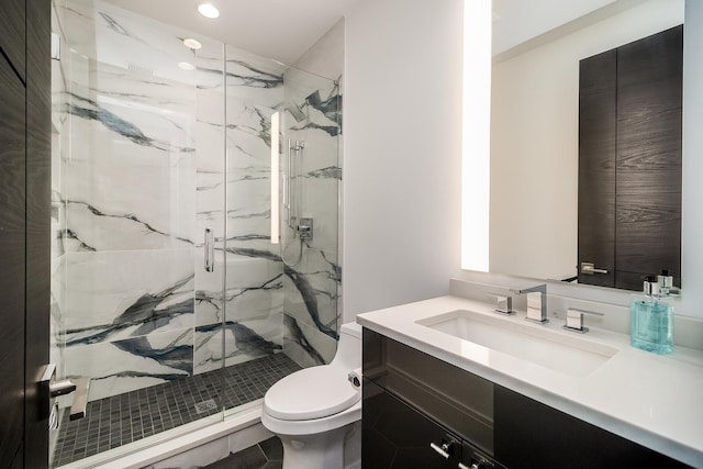 bathroom with tile floors, toilet, vanity, and an enclosed shower