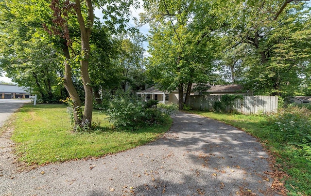 view of property hidden behind natural elements featuring a front yard