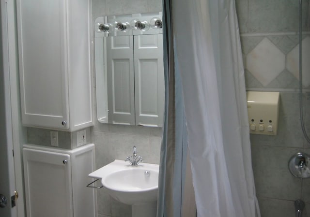 bathroom with tile walls, tasteful backsplash, and sink