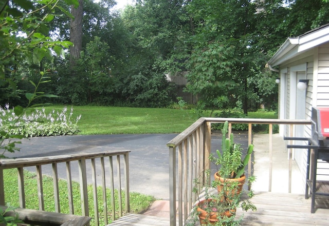 wooden deck featuring a lawn