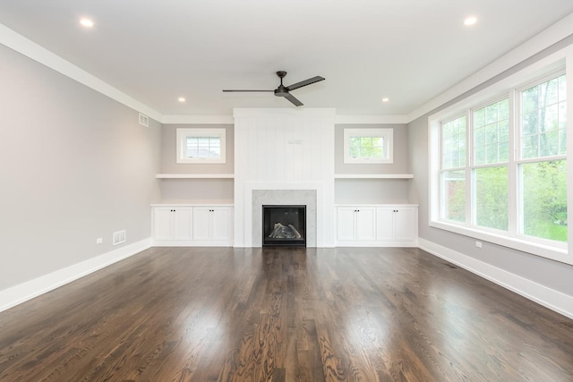 unfurnished living room featuring ceiling fan, a wealth of natural light, and dark hardwood / wood-style floors