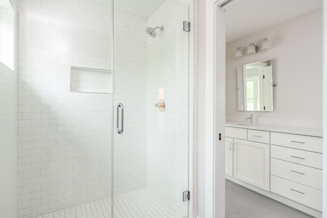 bathroom featuring a shower with shower door, tile floors, and vanity with extensive cabinet space