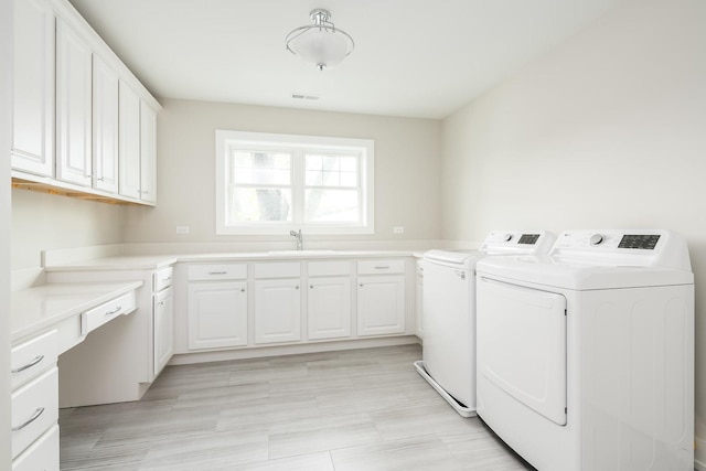 laundry area with sink, cabinets, and washer and dryer