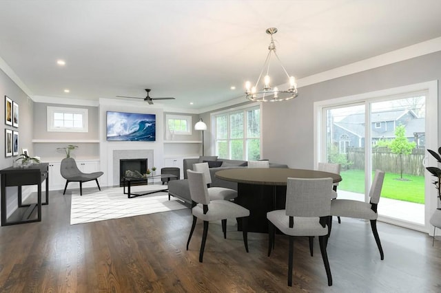 dining space with plenty of natural light, ceiling fan with notable chandelier, dark hardwood / wood-style flooring, and built in shelves