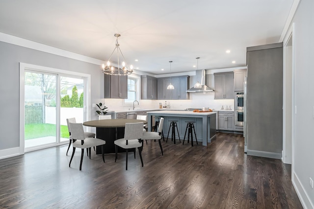 dining room with a notable chandelier, crown molding, dark hardwood / wood-style floors, and sink