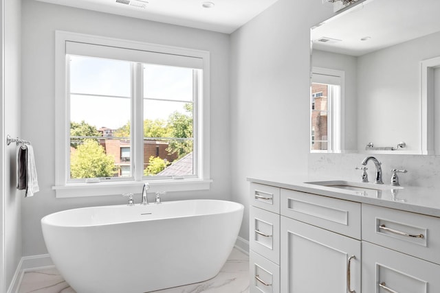 bathroom with tile flooring, a washtub, and vanity with extensive cabinet space