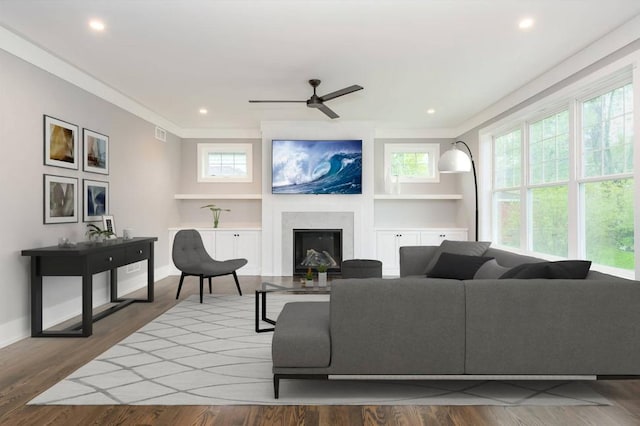 living room with plenty of natural light, ceiling fan, and light hardwood / wood-style flooring