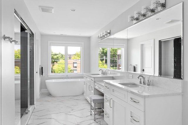 bathroom featuring a bathing tub, dual sinks, tile flooring, and vanity with extensive cabinet space