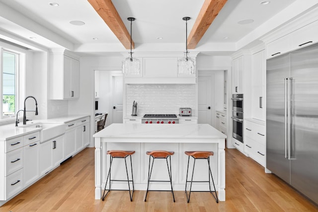 kitchen with stainless steel appliances, backsplash, a center island, and decorative light fixtures