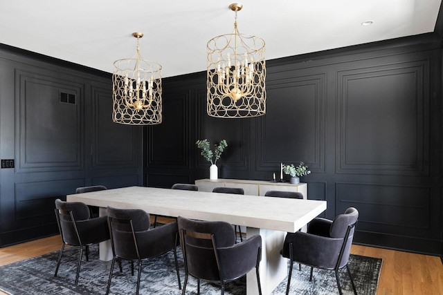 dining area with an inviting chandelier and light wood-type flooring