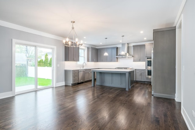 kitchen with decorative light fixtures, gray cabinetry, dark hardwood / wood-style flooring, and wall chimney range hood