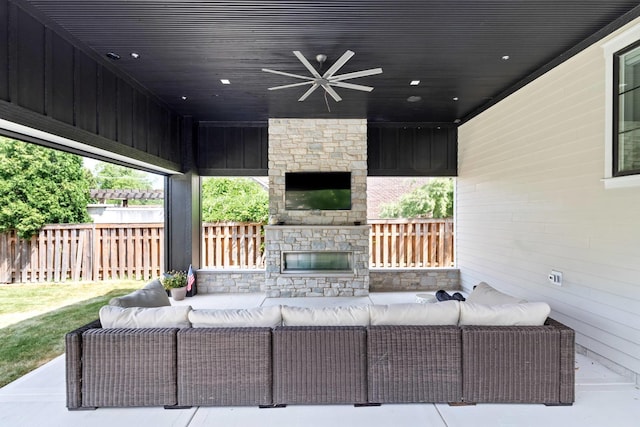 view of patio / terrace with an outdoor living space with a fireplace and ceiling fan