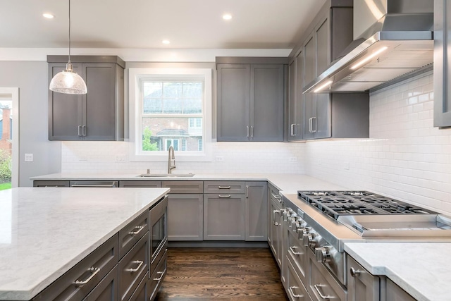 kitchen with wall chimney exhaust hood, gray cabinets, tasteful backsplash, and dark hardwood / wood-style floors