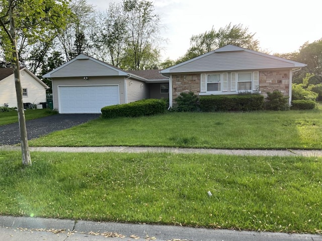 ranch-style home featuring a garage and a front lawn