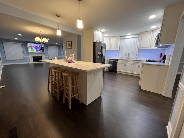 kitchen with stainless steel appliances, white cabinetry, and dark wood-type flooring