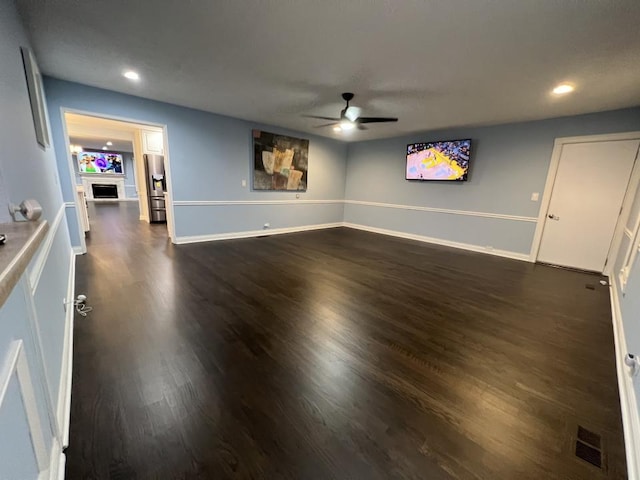 unfurnished living room featuring dark hardwood / wood-style floors and ceiling fan