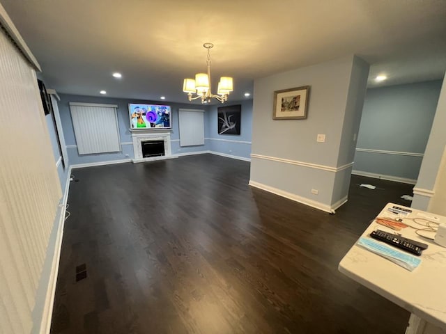 unfurnished living room with dark wood-type flooring and a chandelier