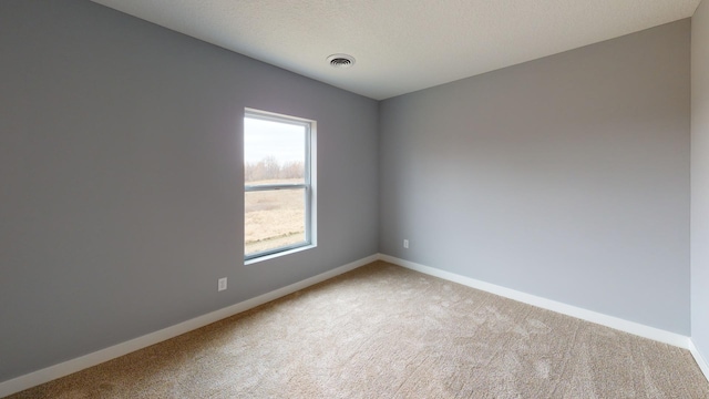 carpeted spare room with a textured ceiling