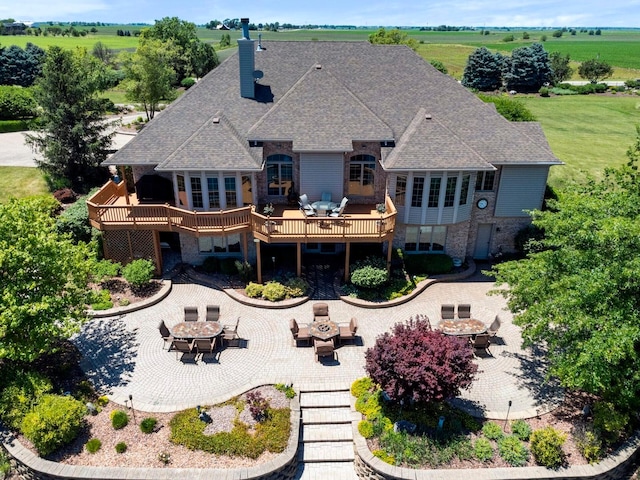 rear view of house with a deck, a yard, and a patio area