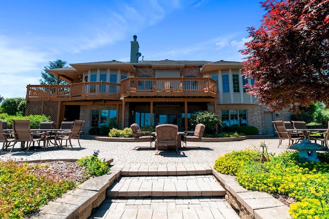 rear view of property featuring a wooden deck and a patio area