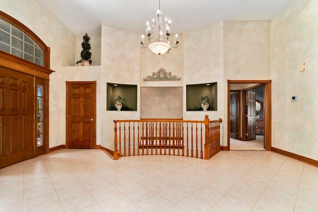 tiled foyer with an inviting chandelier and high vaulted ceiling