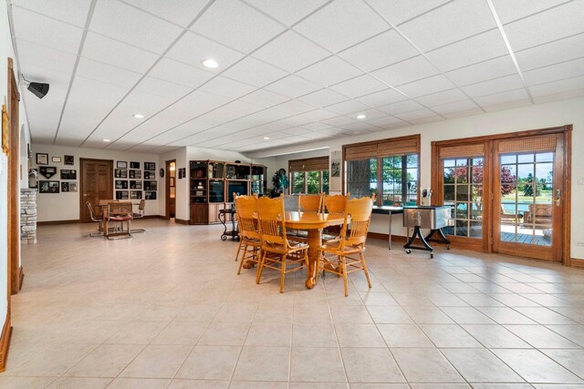 dining area with light tile floors and a drop ceiling