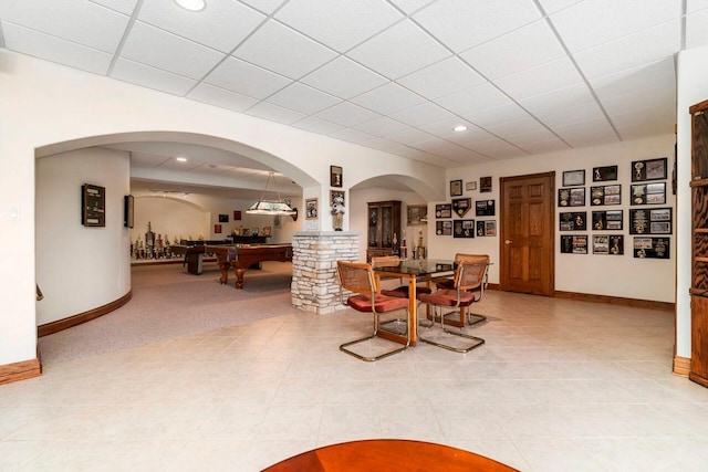 tiled dining space with billiards and a drop ceiling