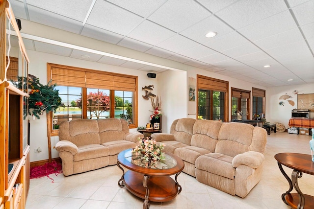 tiled living room featuring a drop ceiling