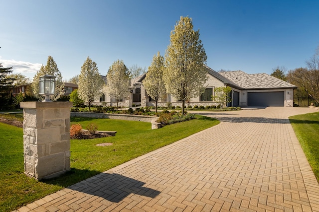 view of front of home with a front yard and a garage