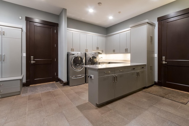 clothes washing area featuring cabinets, separate washer and dryer, and light tile floors