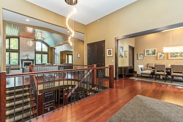 corridor featuring a notable chandelier, vaulted ceiling, and dark wood-type flooring