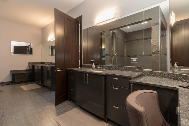 bathroom with a tile shower, tile floors, and vanity with extensive cabinet space