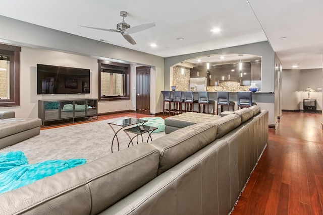 living room with dark hardwood / wood-style floors, ceiling fan, and a wealth of natural light