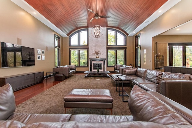 living room with ceiling fan, high vaulted ceiling, dark wood-type flooring, and wooden ceiling