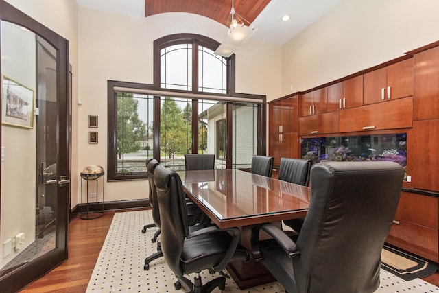 dining area featuring french doors, dark hardwood / wood-style flooring, and a towering ceiling