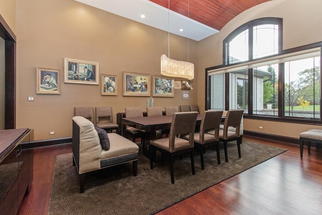 dining space featuring dark wood-type flooring and a high ceiling