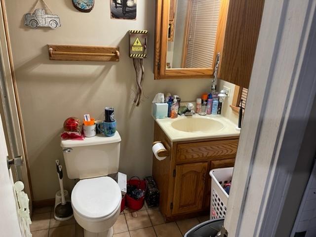 bathroom featuring toilet, tile floors, and vanity with extensive cabinet space