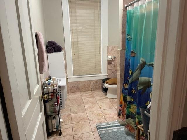 bathroom featuring toilet and tile floors