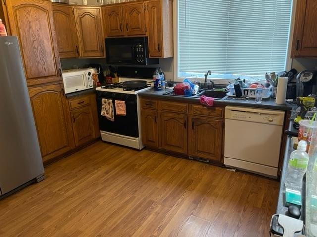 kitchen with white appliances, sink, and light wood-type flooring