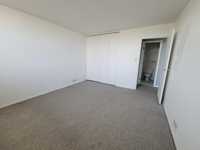 unfurnished bedroom with dark carpet and a closet