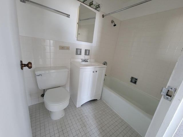 full bathroom with toilet, oversized vanity, tiled shower / bath combo, tile walls, and tile floors