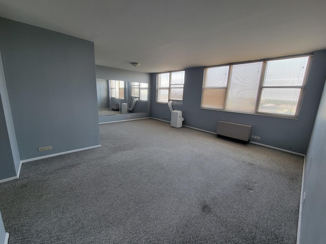 unfurnished room featuring light colored carpet and radiator