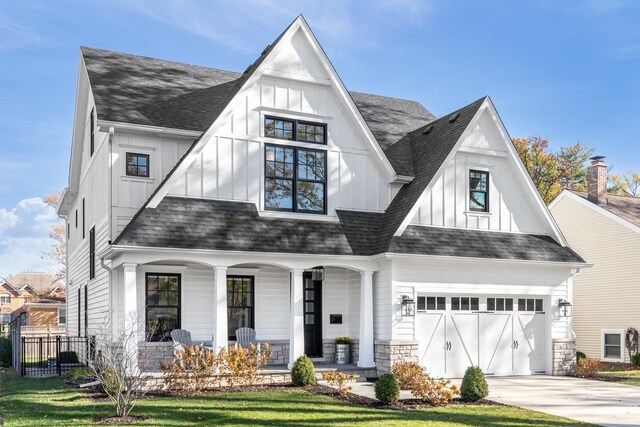 view of front of house featuring covered porch, a shingled roof, and board and batten siding