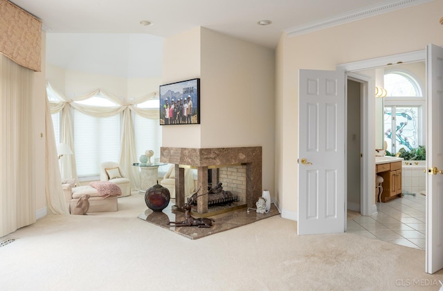 carpeted living room with a multi sided fireplace and ornamental molding