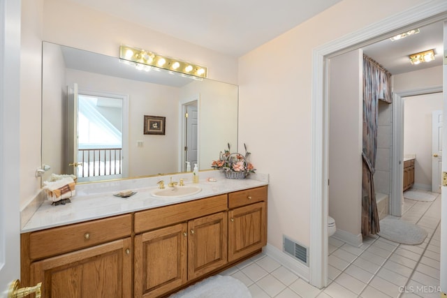 bathroom with vanity, tile floors, and toilet