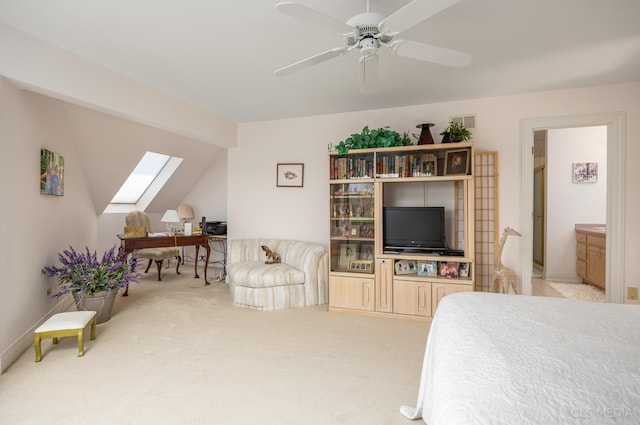 carpeted bedroom with ensuite bath, lofted ceiling with skylight, and ceiling fan