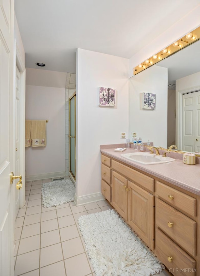 bathroom with a shower with shower door, oversized vanity, and tile floors