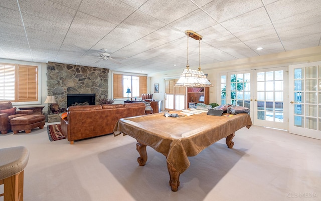 recreation room featuring a stone fireplace, ceiling fan, pool table, and french doors